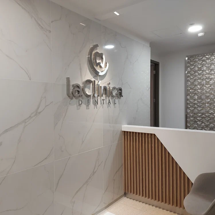 Recepción moderna de la Clínica Dental, con el logo "laClinica DENTAL" en un ambiente elegante y minimalista, destacando la atención al bienestar bucal.